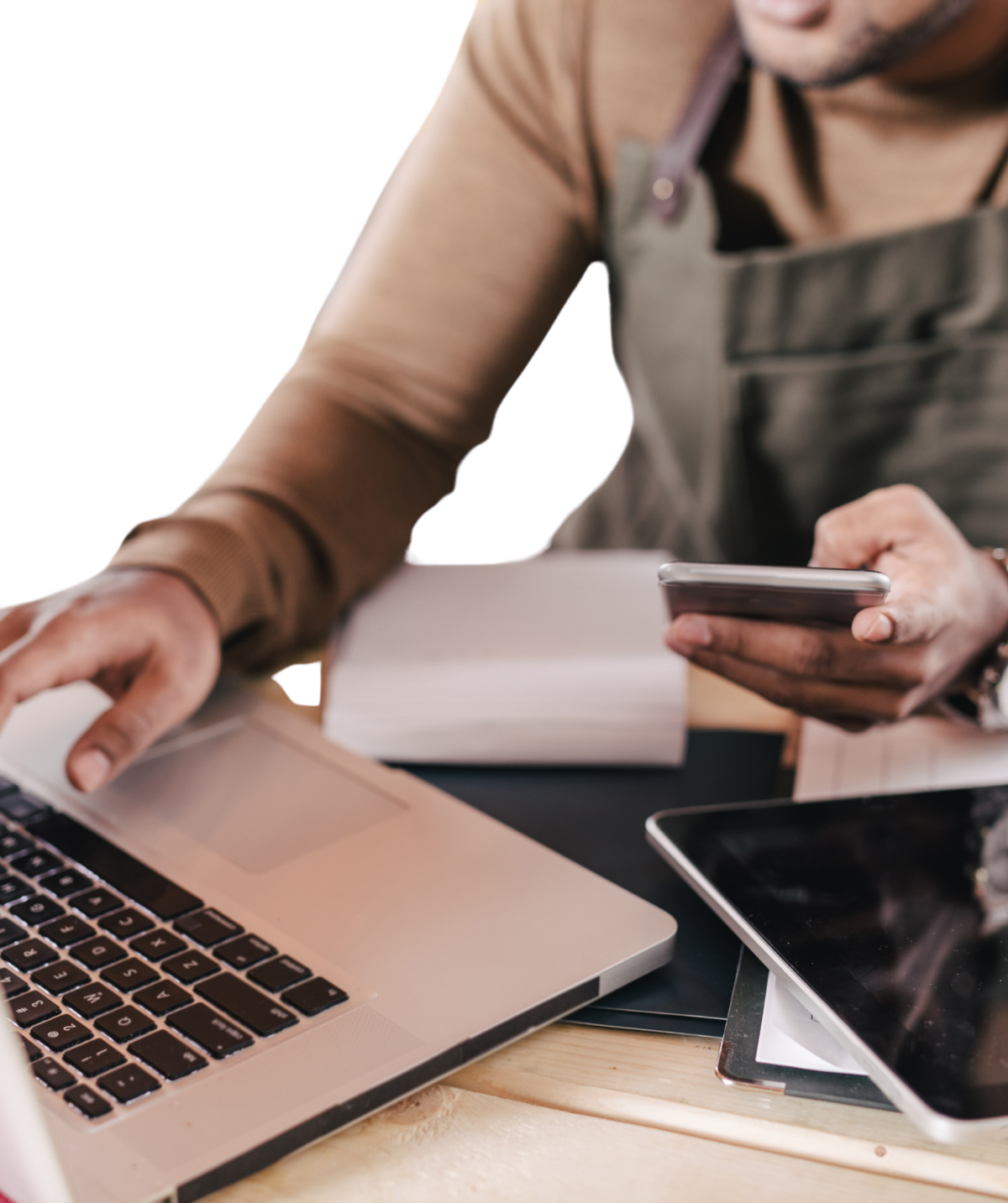 Small-business owner using a laptop and smartphone in her shop — Umbrella IT Group small business IT support